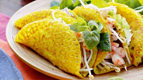 Bánh xèo vàng giòn với tôm, giá đỗ và rau ăn kèm