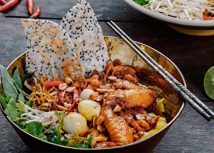Tô mì Quảng với thịt gà, trứng cút, lạc rang, rau sống và bánh tráng nướng