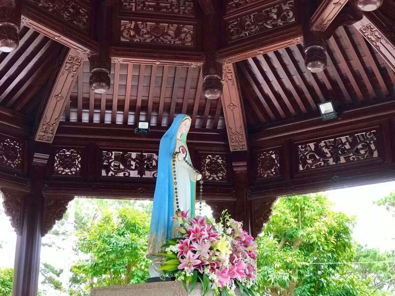 Tượng Đức Mẹ Măng Đen và hoa do khách hành hương dâng kính